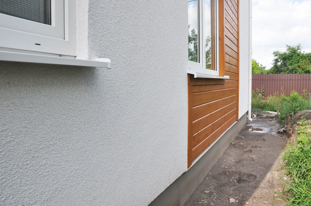 Façade extérieure de maison moderne avec bardage bois horizontal sur soubassement béton