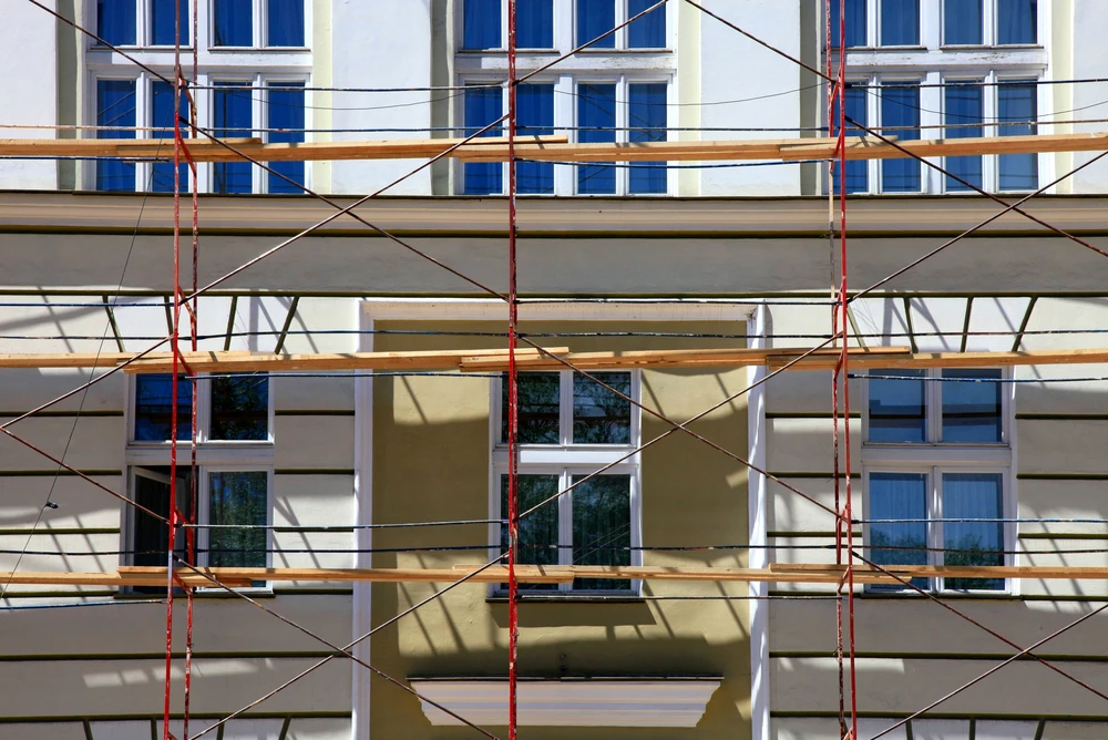 Façade de bâtiment résidentiel en cours de rénovation avec échafaudage tubulaire complet