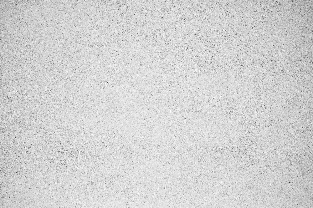 Mur intérieur avec enduit texturé de couleur beige clair, surface uniforme sans éléments décoratifs ni mobilier visible