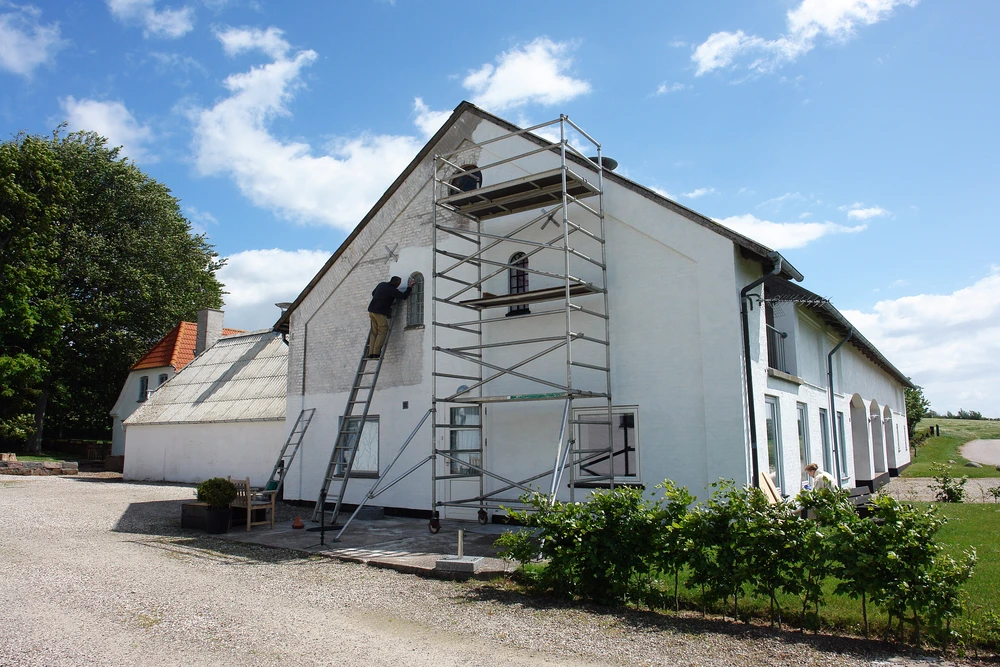 Chantier de rénovation extérieure d'une maison blanche traditionnelle